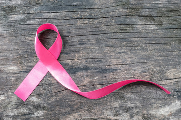 Pink ribbon breast cancer awareness symbolic bow color raising support on people living with...