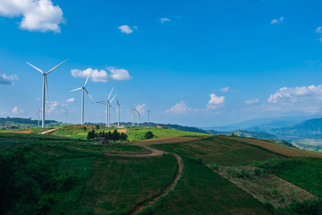 Fototapeta na wymiar clean energy turbine farm with a hut and crop farm