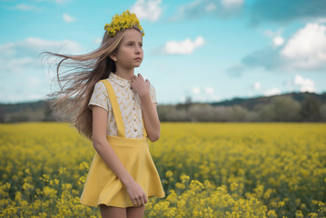 Naklejka na ściany i meble Joven vestida de amarillo en campo de flores amarillas.