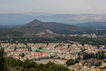 Obraz premium small city from above aerial shot between mountains scenery landscape view in evening time and cloudy and rainy weather