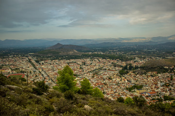 Fototapeta na wymiar small city from above aerial shot between mountains scenery landscape view in evening time and cloudy and rainy weather