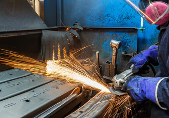 Metal in a factory grinding with sparks