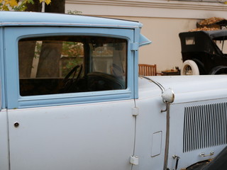 an old car in the yard which is covered with yellow maple leaves