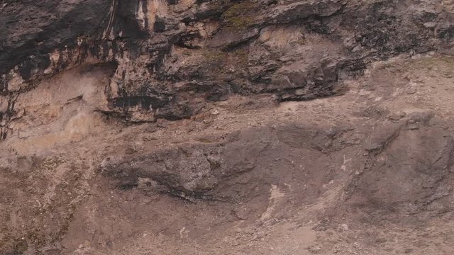 Aerial shot of a run herd of ibex on the steep mountain.