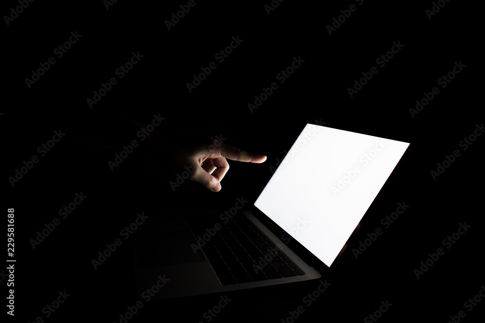 Poster the hand that is pointing at the computer screen. in a dark room. security concep