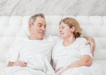 Happy elderly couple together on the bed