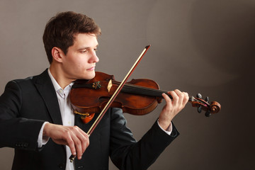 Man man dressed elegantly playing violin © Voyagerix
