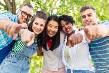 people, friendship and international concept - group of happy friends hugging in park