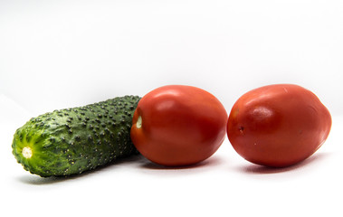 two red tomatoes and one green cucumber
