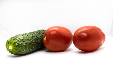 two red tomatoes and one green cucumber