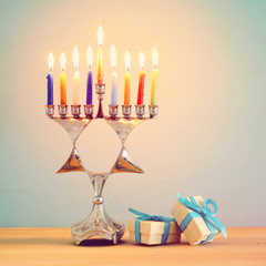 Fototapeta premium image of jewish holiday Hanukkah background with traditional menorah (traditional candelabra) and burning candles.