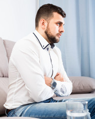 Man feeling distressed and lonely alone at home
