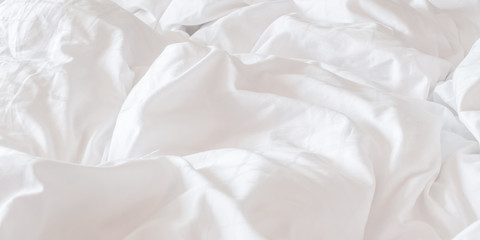 White bed sheet blanket, wrinkled duvet, crumpled comforter cloth used in hotel, resort or home interior for bedding background and sleep comfort