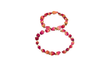 Tea from petals and rosebuds scattered on the table in the shape of a figure eight