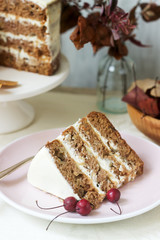 Apple cake with cream, decorated with small apples against the background of autumn composition. Rustic style.