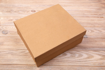Craft closed cardboard package box present on brown wooden table