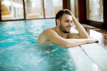 Handsome young man relaxing in hot tub