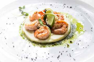 Shrimp with lime on a white plate close-up