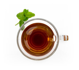 Vaso de cristal con té y una hoja de menta visto cenitalmente