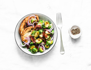 Roasted brussels sprouts with bacon on a light background, top view. Delicious appetizers or snacks