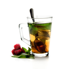 Vaso de cristal con té, menta y frambuesas