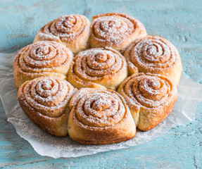 Puff pastry swirls rolls on a wooden blue background. Delicious sweet pastries, dessert
