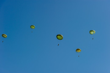 Paratroopers display on blue sky background.