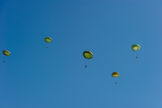 Paratroopers display on blue sky background.