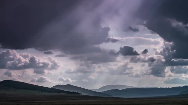 Ray of sunlight through clouds in endless steppes Mongolia. Time lapse