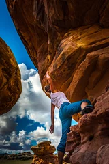 Tuinposter Girl Climber practicing bouldering on a beautiful red rock in Canyonlands Utah USA © Krzysztof Wiktor