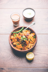 Homemade Kothu Parotta/ Paratha or Stir Fried Leftover Chapati Masala or  fodnichi poli in marathi, served in a bowl or plate with curd and hot tea. Selective focus