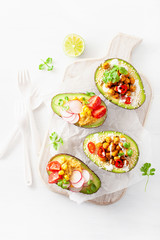 avocado boats stuffed with hummus, tomatoes, radish, roasted chickpea