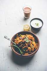 Homemade Kothu Parotta/ Paratha or Stir Fried Leftover Chapati Masala or  fodnichi poli in marathi, served in a bowl or plate with curd and hot tea. Selective focus
