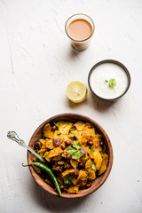Homemade Kothu Parotta/ Paratha or Stir Fried Leftover Chapati Masala or  fodnichi poli in marathi, served in a bowl or plate with curd and hot tea. Selective focus