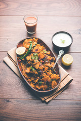 Homemade Kothu Parotta/ Paratha or Stir Fried Leftover Chapati Masala or  fodnichi poli in marathi, served in a bowl or plate with curd and hot tea. Selective focus