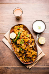 Homemade Kothu Parotta/ Paratha or Stir Fried Leftover Chapati Masala or  fodnichi poli in marathi, served in a bowl or plate with curd and hot tea. Selective focus