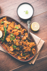 Homemade Kothu Parotta/ Paratha or Stir Fried Leftover Chapati Masala or  fodnichi poli in marathi, served in a bowl or plate with curd and hot tea. Selective focus