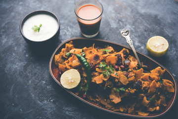 Homemade Kothu Parotta/ Paratha or Stir Fried Leftover Chapati Masala or  fodnichi poli in marathi, served in a bowl or plate with curd and hot tea. Selective focus