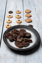 shortbread butter cookies with chocolate and plum jam on a white wooden table