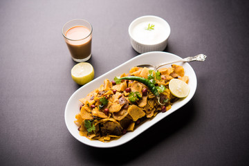 Homemade Kothu Parotta/ Paratha or Stir Fried Leftover Chapati Masala or  fodnichi poli in marathi, served in a bowl or plate with curd and hot tea. Selective focus