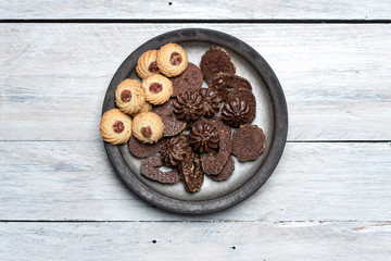 shortbread butter cookies with chocolate and plum jam on a white wooden table