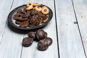 shortbread butter cookies with chocolate and plum jam on a white wooden table
