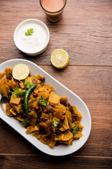 Homemade Kothu Parotta/ Paratha or Stir Fried Leftover Chapati Masala or  fodnichi poli in marathi, served in a bowl or plate with curd and hot tea. Selective focus