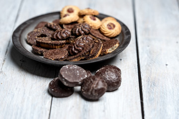 shortbread butter cookies with chocolate and plum jam on a white wooden table