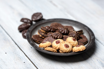 shortbread butter cookies with chocolate and plum jam on a white wooden table