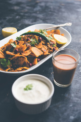 Homemade Kothu Parotta/ Paratha or Stir Fried Leftover Chapati Masala or  fodnichi poli in marathi, served in a bowl or plate with curd and hot tea. Selective focus