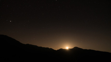 Starry night with moon setting beneath the mountains, Artvin, Turkey