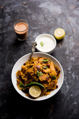 Homemade Kothu Parotta/ Paratha or Stir Fried Leftover Chapati Masala or  fodnichi poli in marathi, served in a bowl or plate with curd and hot tea. Selective focus