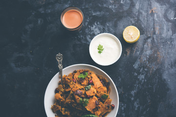 Homemade Kothu Parotta/ Paratha or Stir Fried Leftover Chapati Masala or  fodnichi poli in marathi, served in a bowl or plate with curd and hot tea. Selective focus