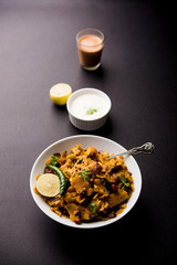 Homemade Kothu Parotta/ Paratha or Stir Fried Leftover Chapati Masala or  fodnichi poli in marathi, served in a bowl or plate with curd and hot tea. Selective focus